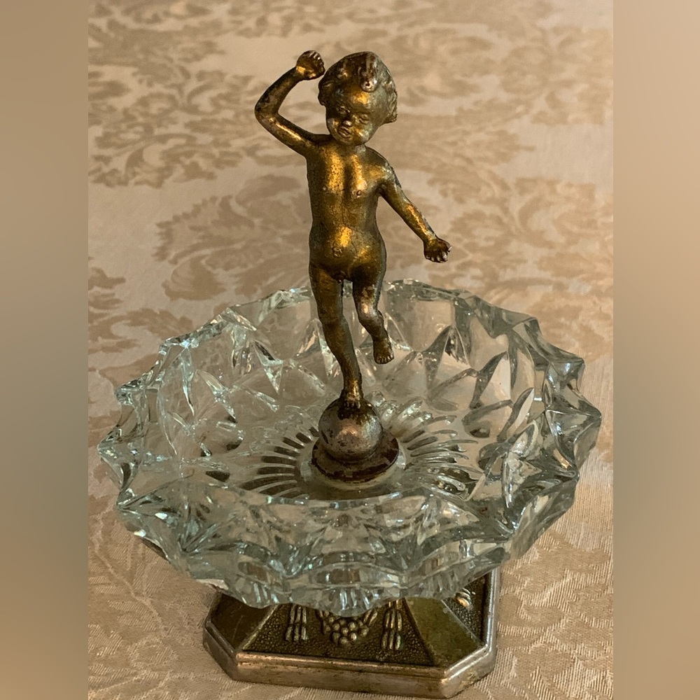 Antique glass ash tray with metal stand and metal little boy statue.